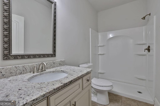 bathroom featuring tile patterned flooring, vanity, toilet, and walk in shower