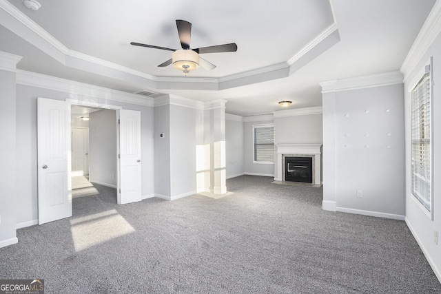 unfurnished living room with dark colored carpet, a raised ceiling, and ornamental molding