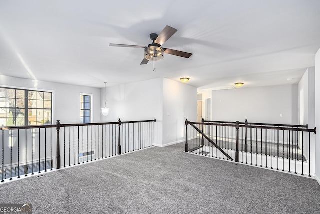 carpeted spare room featuring ceiling fan