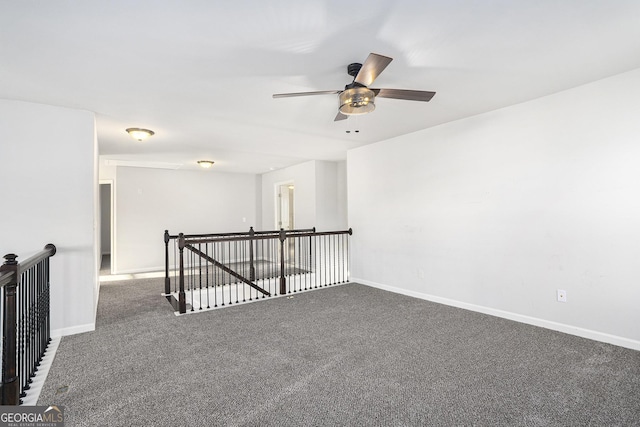 unfurnished room featuring ceiling fan and dark carpet