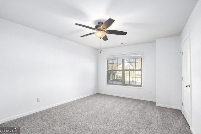 carpeted spare room featuring ceiling fan