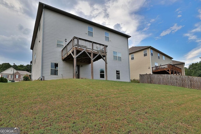 back of property with a lawn and a deck