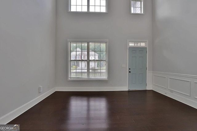 entrance foyer featuring dark hardwood / wood-style flooring and a towering ceiling