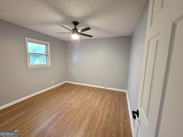 spare room featuring a textured ceiling, ceiling fan, and wood-type flooring