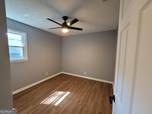 unfurnished room featuring ceiling fan, dark hardwood / wood-style floors, and a textured ceiling