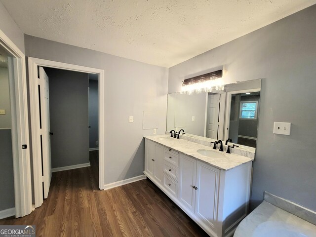 bathroom with hardwood / wood-style floors, a textured ceiling, and vanity