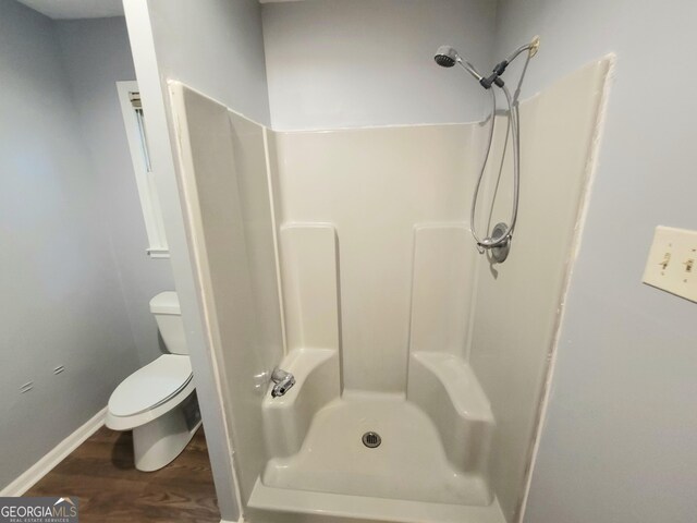 bathroom with toilet, hardwood / wood-style flooring, and walk in shower