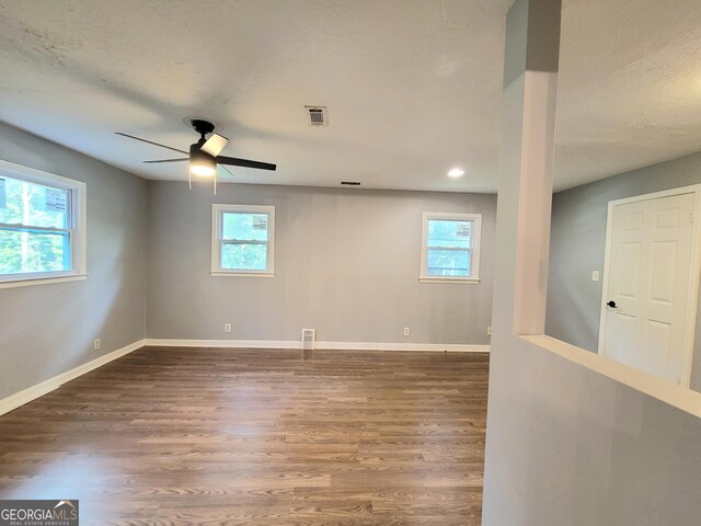 unfurnished room featuring wood-type flooring, ceiling fan, and a healthy amount of sunlight