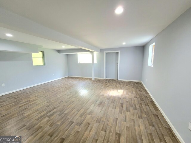 basement with a healthy amount of sunlight and hardwood / wood-style floors