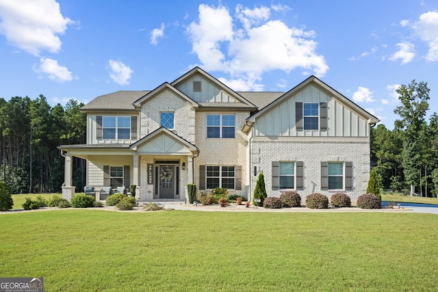 craftsman inspired home featuring a front lawn, brick siding, and board and batten siding