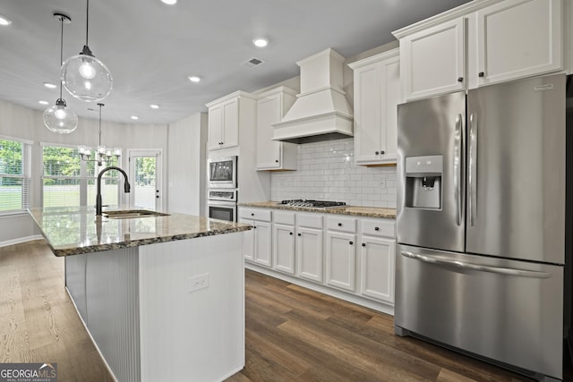 kitchen featuring a sink, custom exhaust hood, white cabinetry, and stainless steel appliances