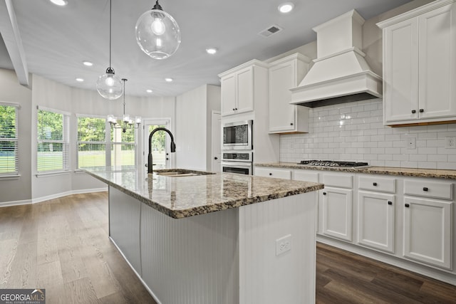 kitchen with visible vents, a sink, stainless steel appliances, dark wood-type flooring, and custom range hood