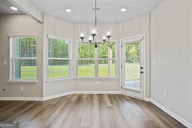 unfurnished dining area with visible vents, baseboards, recessed lighting, wood finished floors, and a notable chandelier