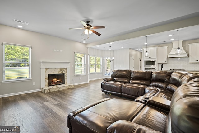 living room featuring visible vents, a healthy amount of sunlight, wood finished floors, and a fireplace