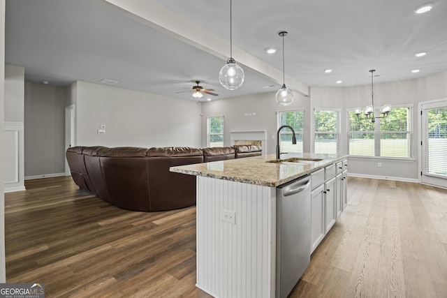 kitchen featuring a sink, white cabinetry, a fireplace, light stone countertops, and dishwasher