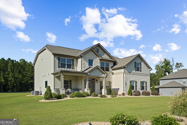 craftsman house featuring a front yard, central AC unit, covered porch, board and batten siding, and brick siding