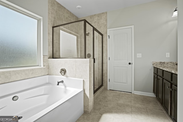 bathroom with vanity, a shower stall, a garden tub, and tile patterned floors