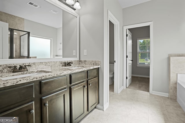 full bath with visible vents, a stall shower, a sink, toilet, and a washtub