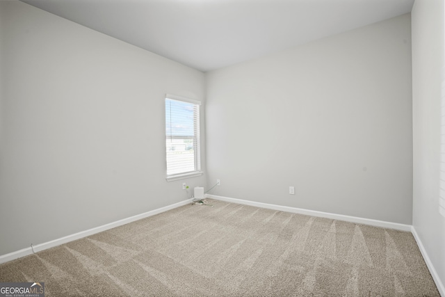 spare room with baseboards and carpet floors