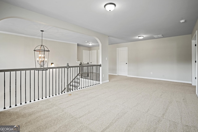 unfurnished room featuring visible vents, carpet floors, arched walkways, baseboards, and a chandelier