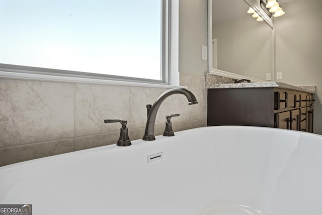 bathroom with vanity and a freestanding tub