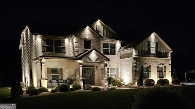 view of front of home featuring stone siding and a lawn