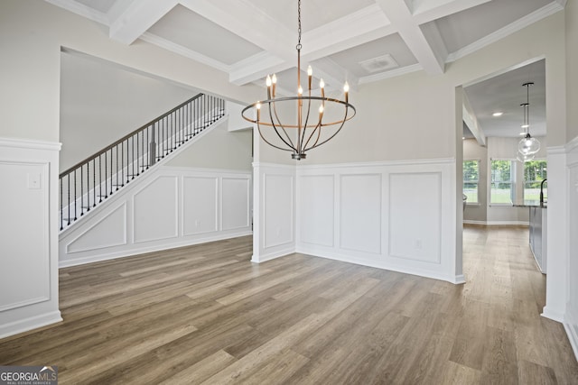 unfurnished dining area featuring a decorative wall, beamed ceiling, stairs, and wood finished floors