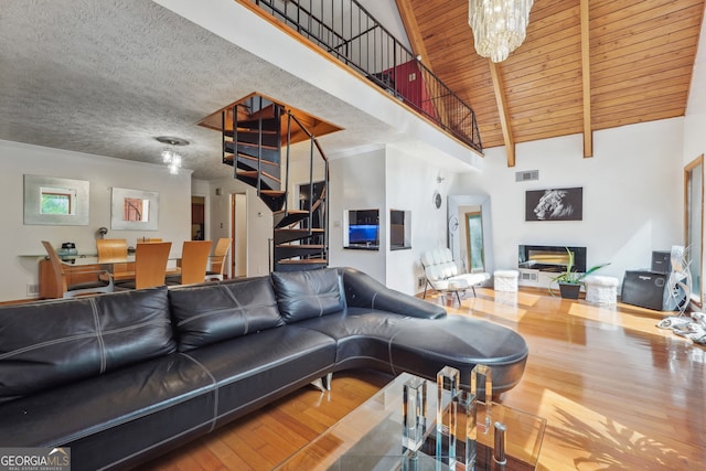 living room featuring wood-type flooring, a textured ceiling, a chandelier, high vaulted ceiling, and wooden ceiling