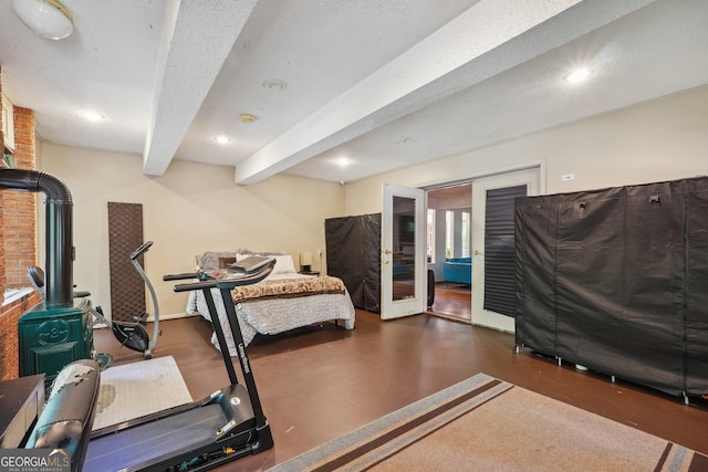 workout room with a wood stove, a textured ceiling, and french doors