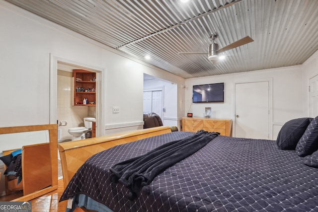 bedroom featuring wood-type flooring, connected bathroom, crown molding, and ceiling fan