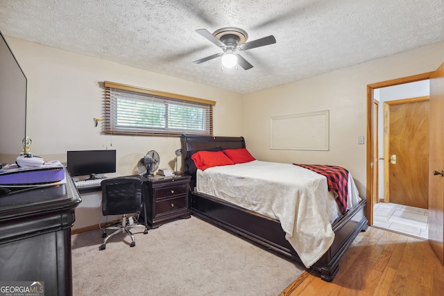 bedroom featuring a textured ceiling, ceiling fan, and light hardwood / wood-style flooring