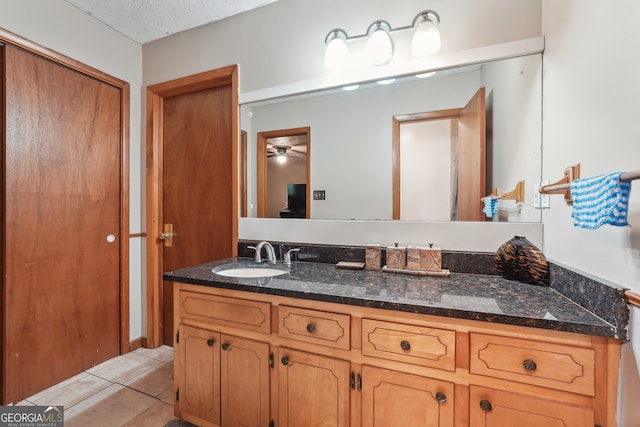 bathroom featuring tile patterned flooring, ceiling fan, vanity, and a textured ceiling