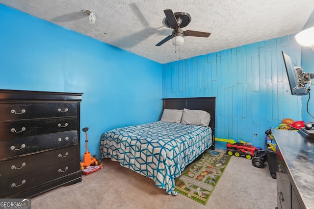 bedroom featuring ceiling fan, light colored carpet, and a textured ceiling