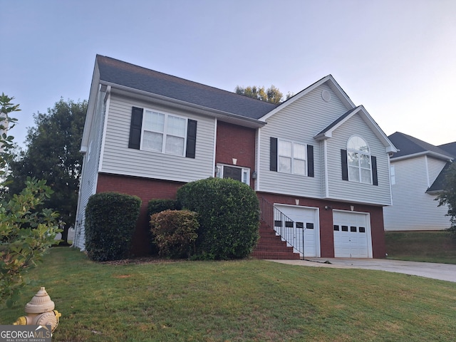 bi-level home featuring a garage and a front lawn