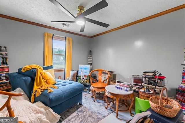 recreation room featuring a textured ceiling, ceiling fan, and ornamental molding