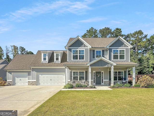 craftsman-style home with a garage, covered porch, and a front yard