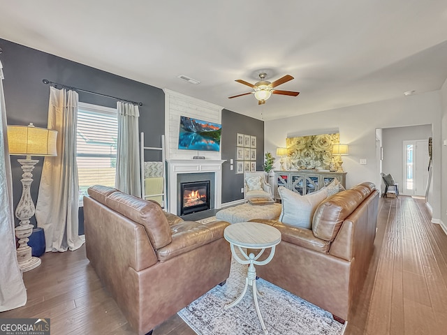 living room featuring dark hardwood / wood-style flooring, plenty of natural light, and ceiling fan