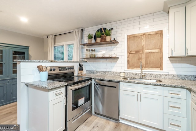 kitchen featuring light wood-type flooring, appliances with stainless steel finishes, white cabinetry, and sink