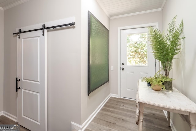 doorway featuring crown molding, a barn door, and light hardwood / wood-style floors