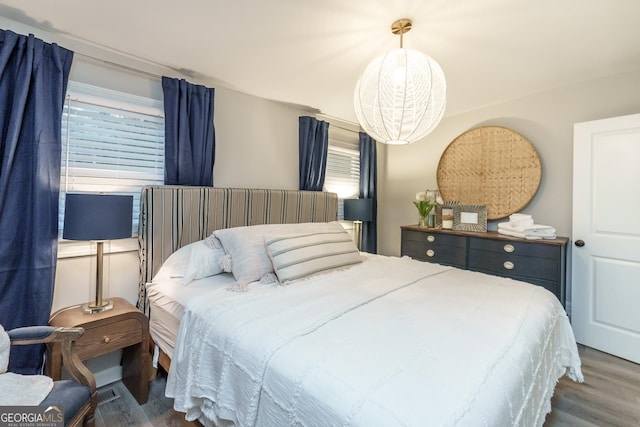 bedroom with dark wood-type flooring and a notable chandelier