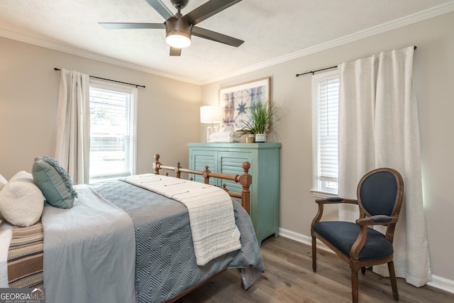 bedroom with wood-type flooring, crown molding, and ceiling fan