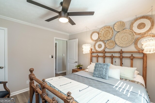 bedroom featuring ceiling fan, crown molding, and wood-type flooring