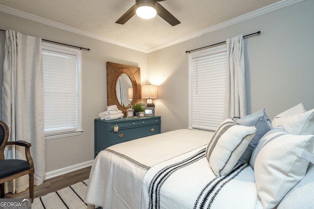 bedroom with a ceiling fan, baseboards, crown molding, and wood finished floors