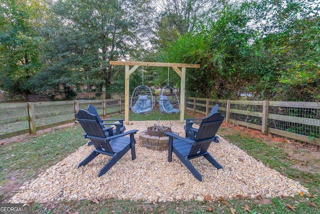 view of yard featuring fence, a fire pit, and a playground