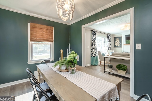 dining space featuring hardwood / wood-style flooring, a textured ceiling, a notable chandelier, and ornamental molding