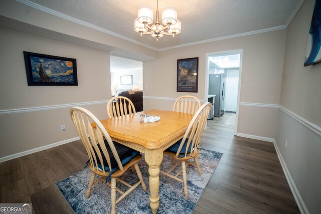 dining area featuring a textured ceiling, crown molding, dark hardwood / wood-style flooring, and a chandelier