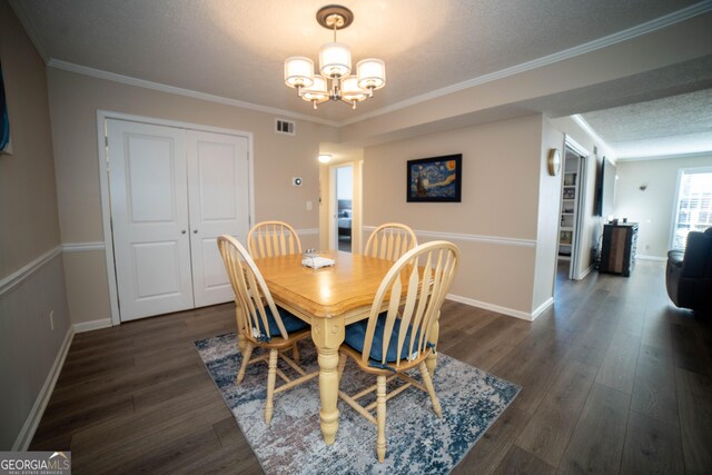 dining space with an inviting chandelier, crown molding, a textured ceiling, and dark hardwood / wood-style flooring