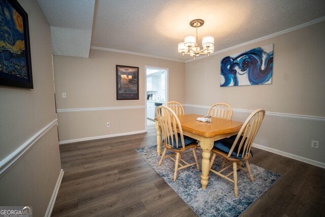 dining area featuring a chandelier, a textured ceiling, dark hardwood / wood-style floors, and crown molding