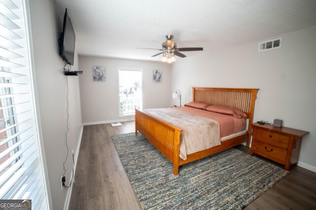 bedroom with dark hardwood / wood-style floors and ceiling fan