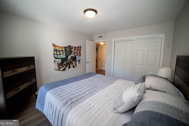 bedroom with a closet and dark wood-type flooring